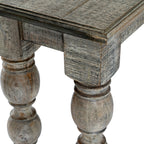Close view of the console table corner, with a bordered top, square upper leg sections and rounded forms beneath a distressed grey-brown finish.
