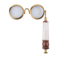 Front view of the magnifier with two round gold-toned lens frames and a vertical white and brown handle on a white background.