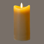 Taupe LED candle photographed against a grey background, with the flame-shaped detail appearing bright white and a golden glow around the curved top.
