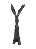 Front view of a black upright hare sculpture with long ears, an elongated body and small forepaws against its chest.