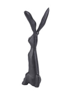 Rear angled view of the black hare sculpture showing its narrow back, upright ears and rounded tail.