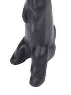 Close-up of the black hare sculpture's forepaws, lower body and feet with softly reflective surface texture.