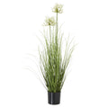 Full view of a tall artificial arrangement with white flower clusters above long green leaves in a black pot.