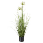 Full view of a tall artificial arrangement with white flower clusters above long green leaves in a black pot.