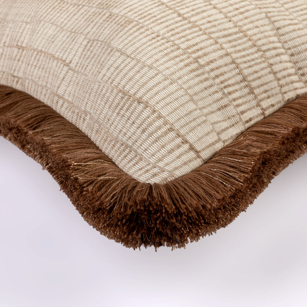 Close-up of the Vanta Cushion showing its cream striped weave and brown fringe