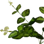 Close-up of the artificial spray showing irregular light green leaf patterns, fine vein-like markings and pale tip growth on slender stems.