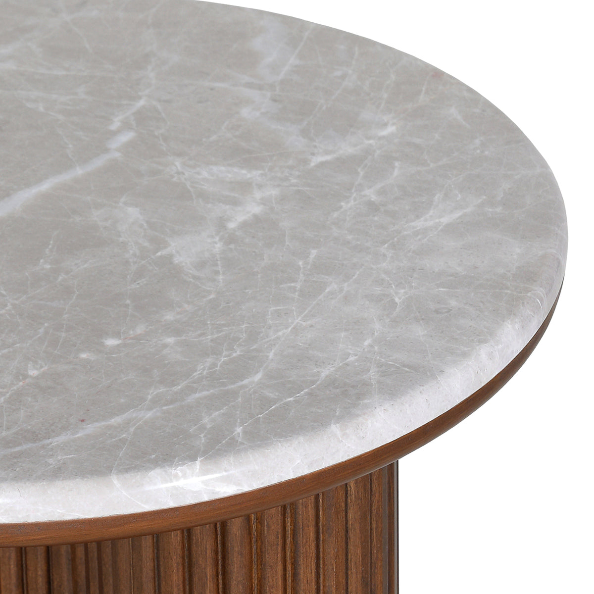 Close view of white veining across the pale grey marble top and its rounded edge above the brown wood base.