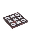Angled view of a square burgundy marble noughts-and-crosses board with white veining and pale stone pieces sitting in nine circular recesses.