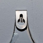 Close-up of the mirror's reverse showing a keyhole-shaped opening in a small plate against the grey backing.