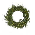 Green artificial wreath with dense fir-style sprays, an open circular centre and warm lights, shown against a white background.