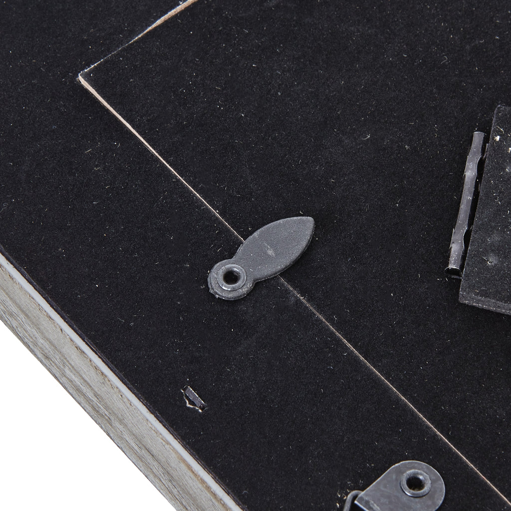 Close-up of a rotating retaining tab across the edge of the black rear panel, with the easel hinge visible to the right.