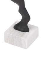 Close-up of the sculpture's curved lower stem meeting a pale marble block base with subtle veining.