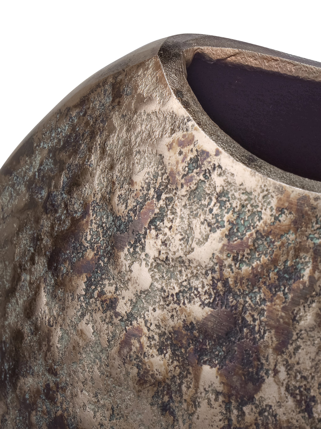 Close-up of the dipped rim and dark interior above a textured bronze-toned surface with green-grey markings.