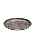 Angled view of a shallow round platter with a mottled bronze and green surface and gently raised rim.