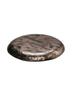 Underside of the round platter, showing the mottled metallic finish and three dark circular pads.
