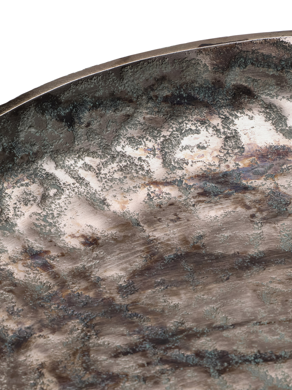 Close-up of the platter's curved rim and textured interior, with dark and green patches over a bronze-toned surface.