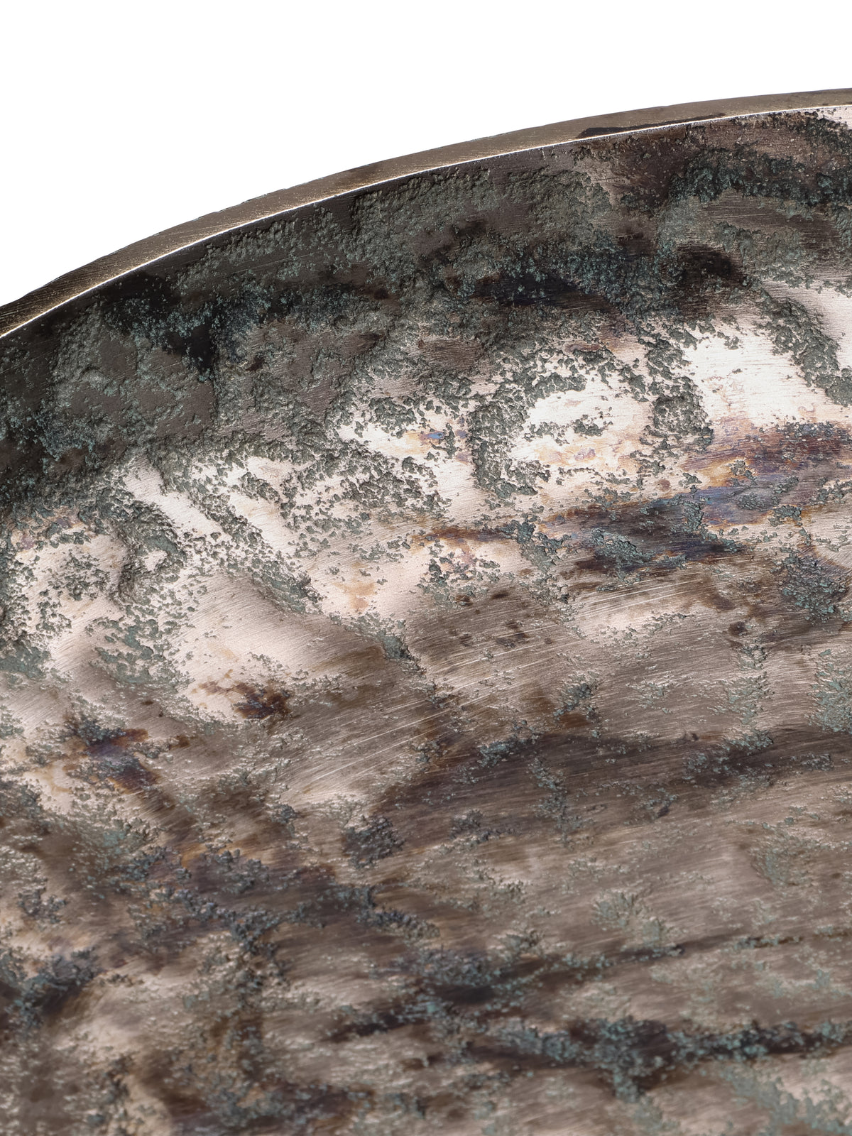 Close-up of the platter's curved rim and textured interior, with dark and green patches over a bronze-toned surface.