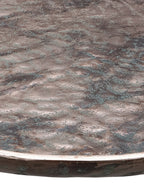 Close-up across the platter's rippled surface, showing fine green mottling and a bright bronze-toned rim.