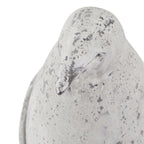 Close-up of the penguin ornament's head and short beak, with a small round eye and scattered grey markings across the pale surface.