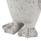 Detail of the penguin ornament's rounded lower body and webbed feet, showing raised toes and irregular grey markings.