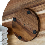 Close-up of the circular underside base plate showing a central fastener and four black pads, beside part of the stacked white dishes.