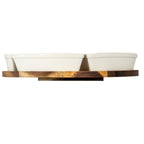 Low side view of warm-white dishes on the brown grained platform, with its smaller base plate visible beneath.
