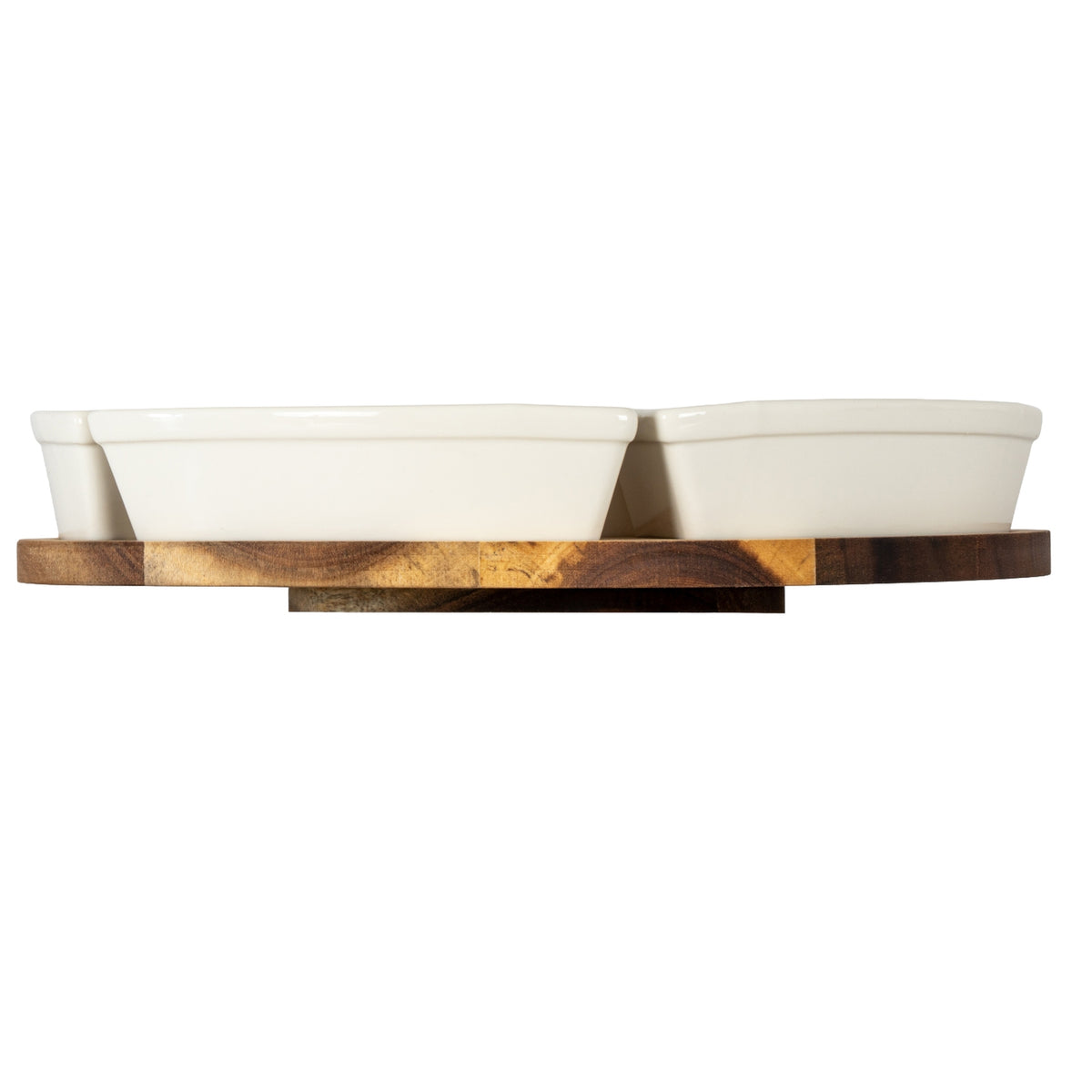 Low side view of warm-white dishes on the brown grained platform, with its smaller base plate visible beneath.