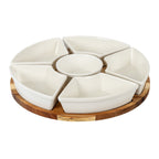Angled view of five glossy warm-white wedge dishes surrounding a round bowl on a circular brown grained platform.