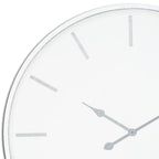 Close-up of the clock's pale face showing grey baton markers, shaped hand tips and the narrow white rim.