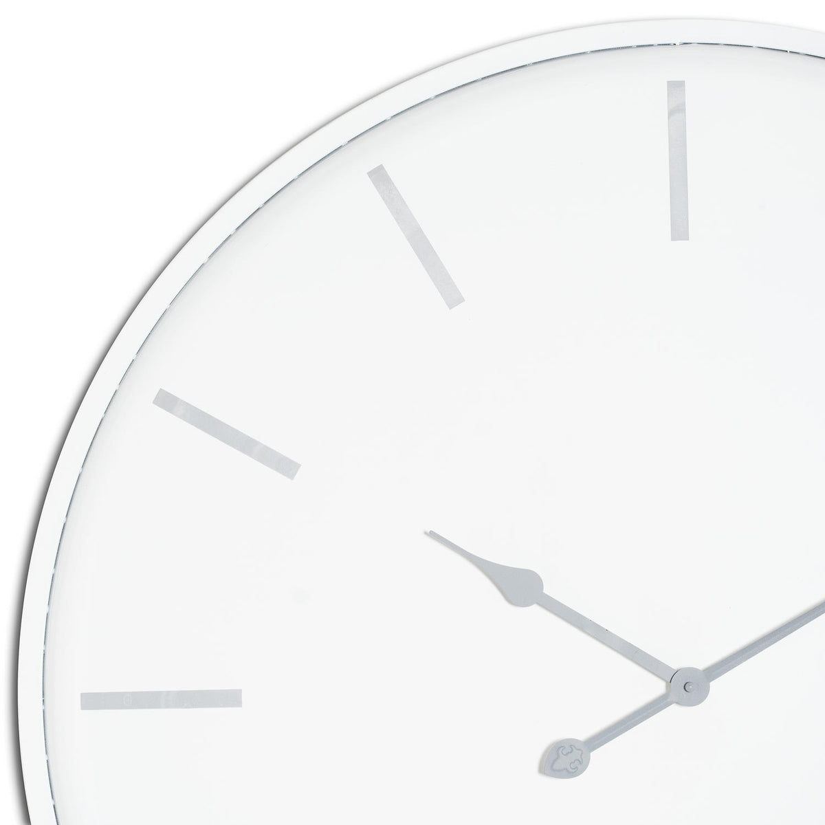 Close-up of the clock's pale face showing grey baton markers, shaped hand tips and the narrow white rim.