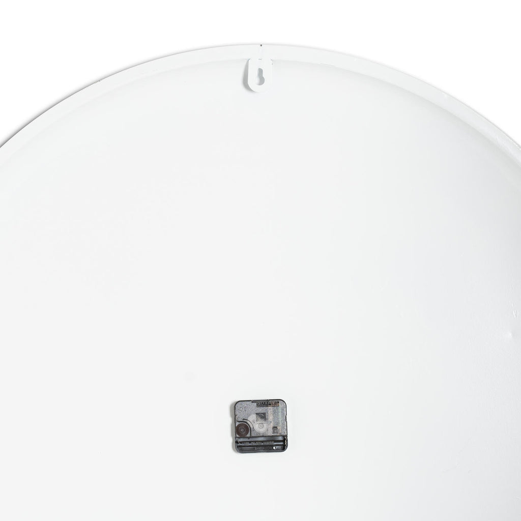 Rear view of the clock showing a plain white circular back, a small dark movement and a keyhole-cut hanging tab at the top.