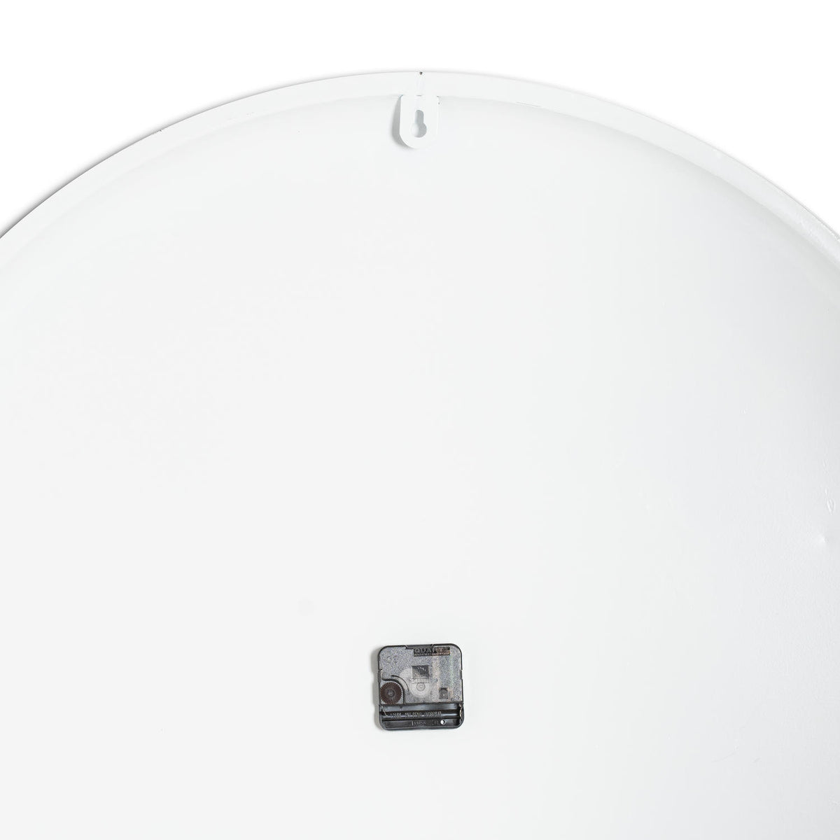 Rear view of the clock showing a plain white circular back, a small dark movement and a keyhole-cut hanging tab at the top.