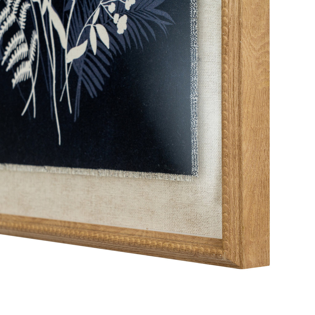 Angled close-up of the artwork's lower right corner, showing the textured pale surround, dark botanical print and beaded detail on the warm-toned frame.