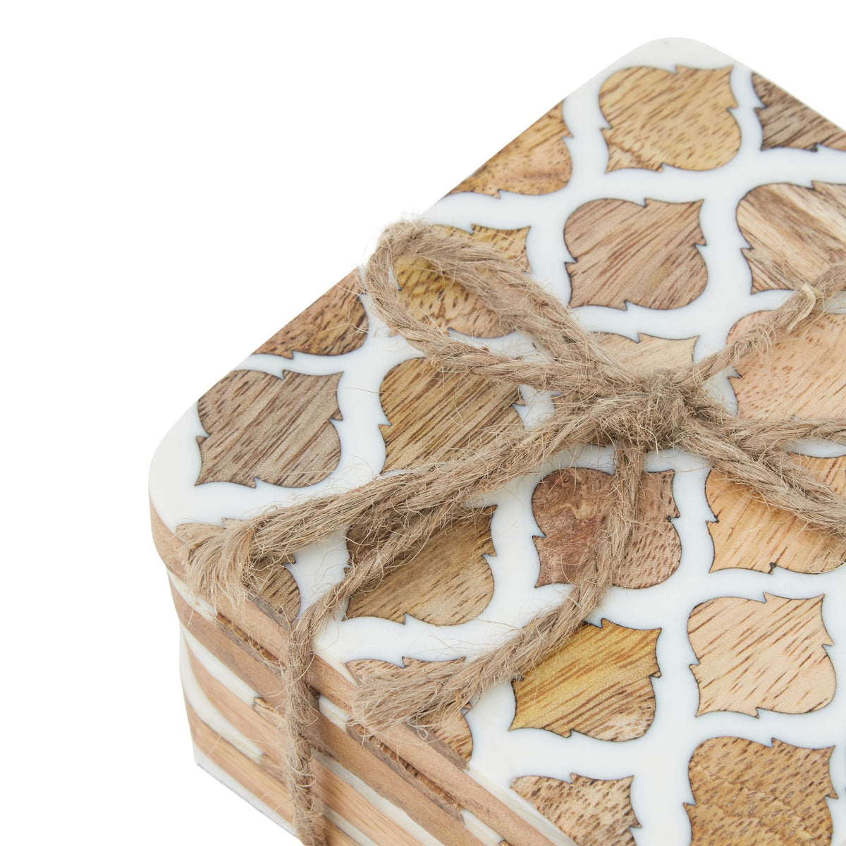 Close-up of the top coaster and twine bow, showing varied tan grain within repeated motifs separated by white lines.