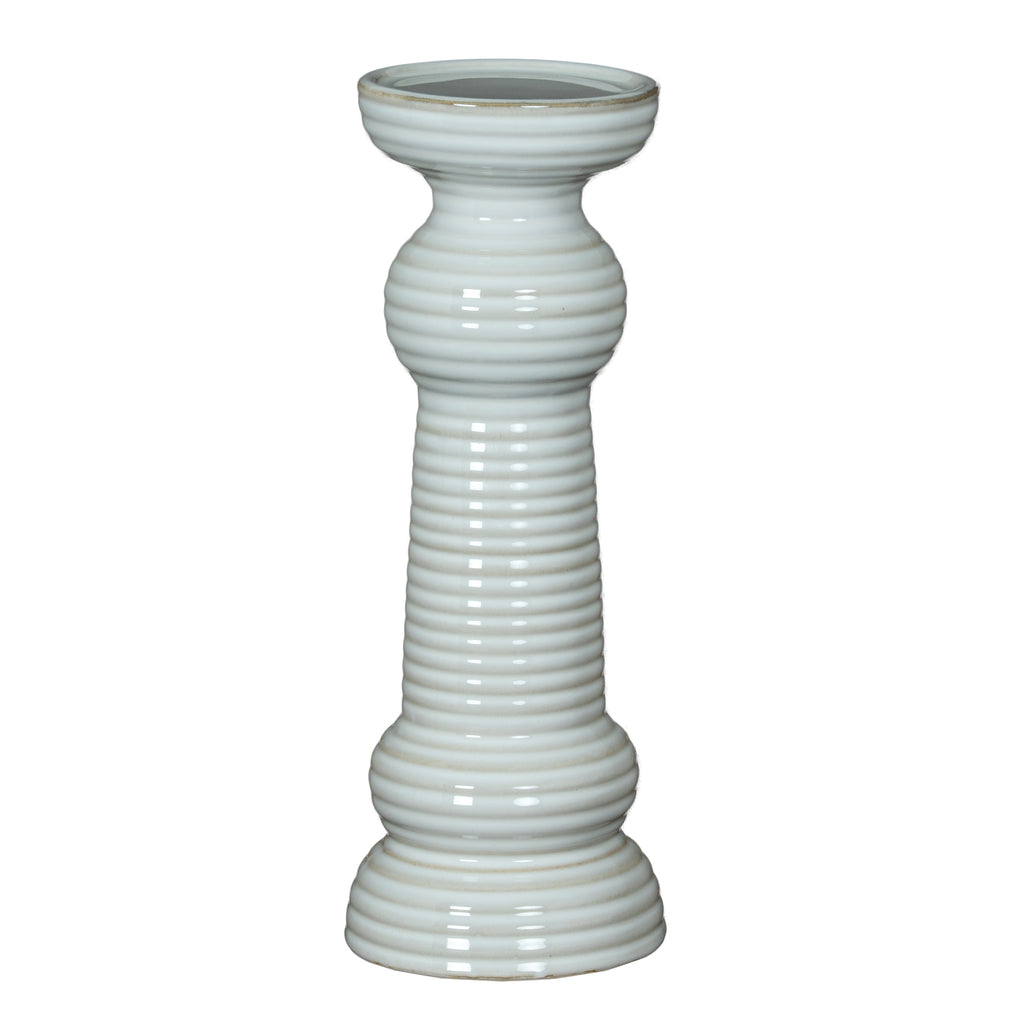 Full view of a glossy white pillar candle holder with a broad circular cup, ribbed column, rounded collars and tiered flared foot.