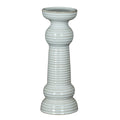 Full view of a glossy white pillar candle holder with a broad circular cup, ribbed column, rounded collars and tiered flared foot.
