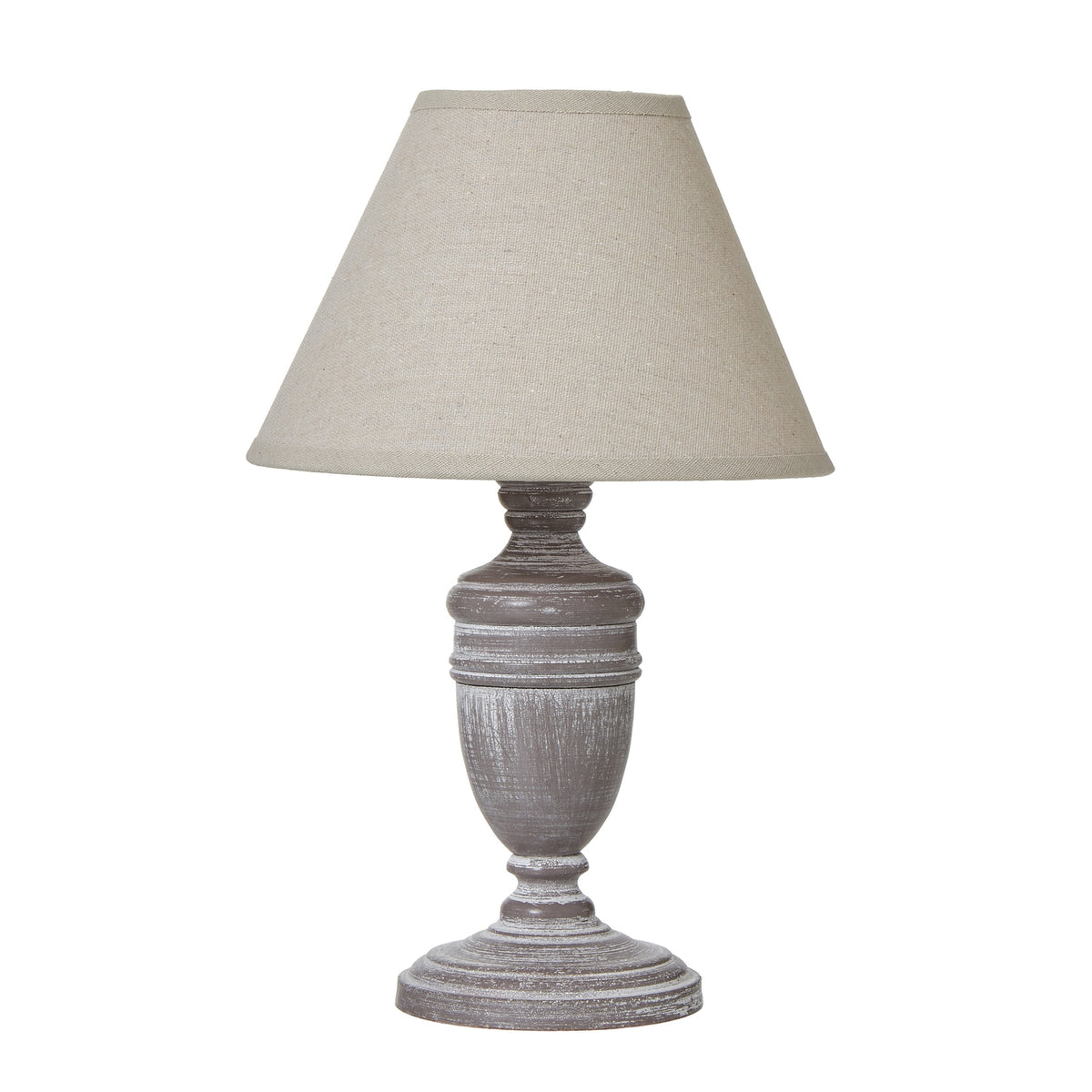Table lamp with a tapered tan-coloured shade above a grey-brown urn-shaped base with rubbed white markings and a round foot