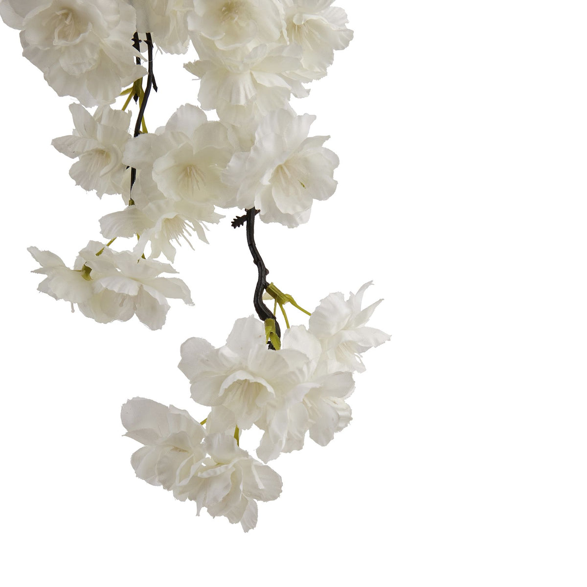 Close-up of layered white artificial blossoms along dark twigs, with small pale-green attachment details beneath the flowers.