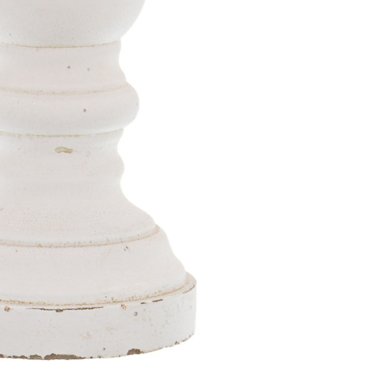 Close-up of the candle holder's lower curves and stepped base, showing warm rubbed lines and small specks across the matt-white surface.