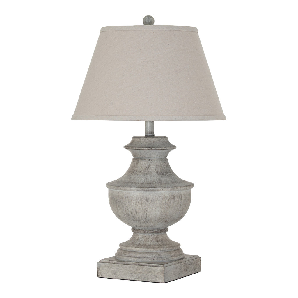 White-grey urn-shaped table lamp on a square plinth, with a pale tapered shade and ball finial against a white background.