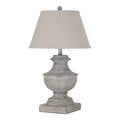 White-grey urn-shaped table lamp on a square plinth, with a pale tapered shade and ball finial against a white background.