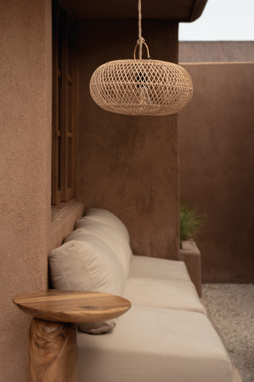Wholly Rattan Pendant Light – Natural, Small — styled above a bedside table