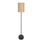 Whorl Base Floor Lamp on white, with a tall tan cylindrical shade, slender black pole and rounded black patterned base.