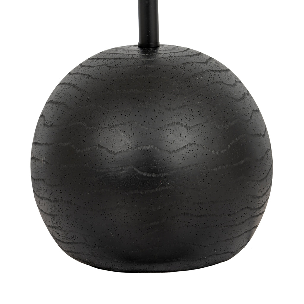 Close view of the rounded black lamp base, showing wavy grain-like bands and fine surface texture around the pole.