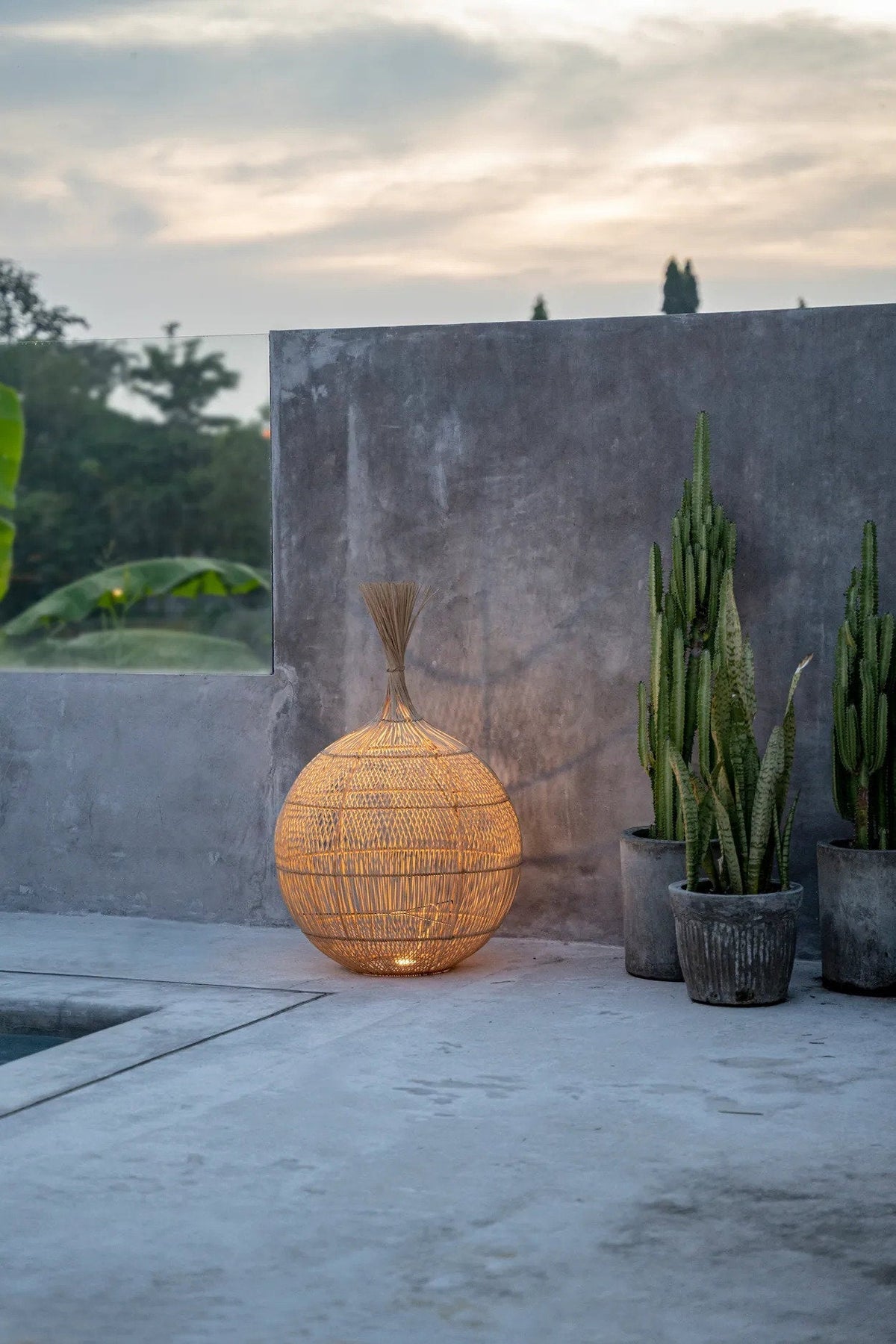Wonton Rattan Floor/Pendant Shade – Natural — standing in a styled terrace setting
