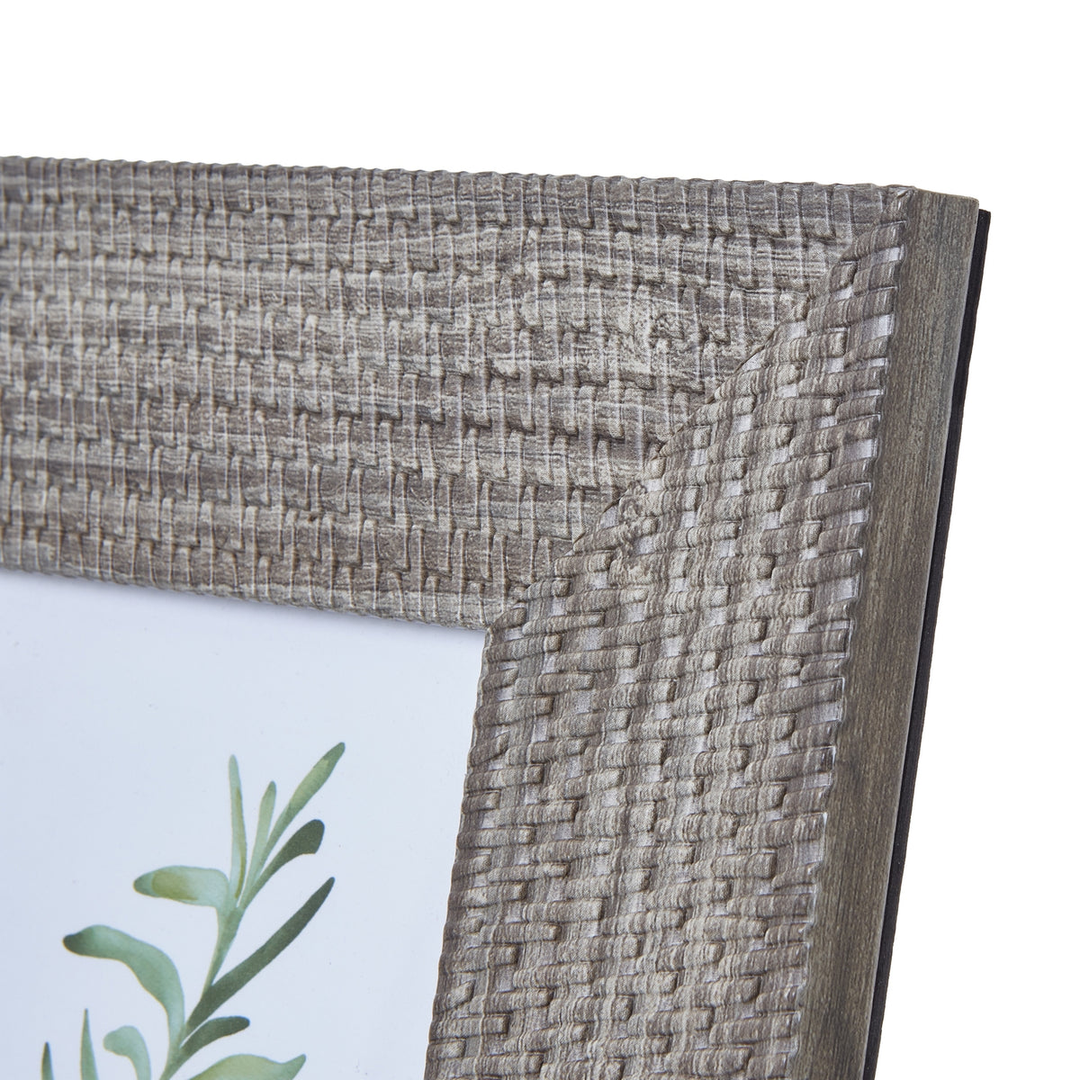 Close-up of the photo frame's upper right corner, showing pale highlights across the woven-look pattern and its plain side edge.