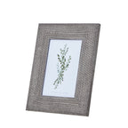 Angled front view of a grey photo frame with a wide woven-texture border around a green botanical insert.