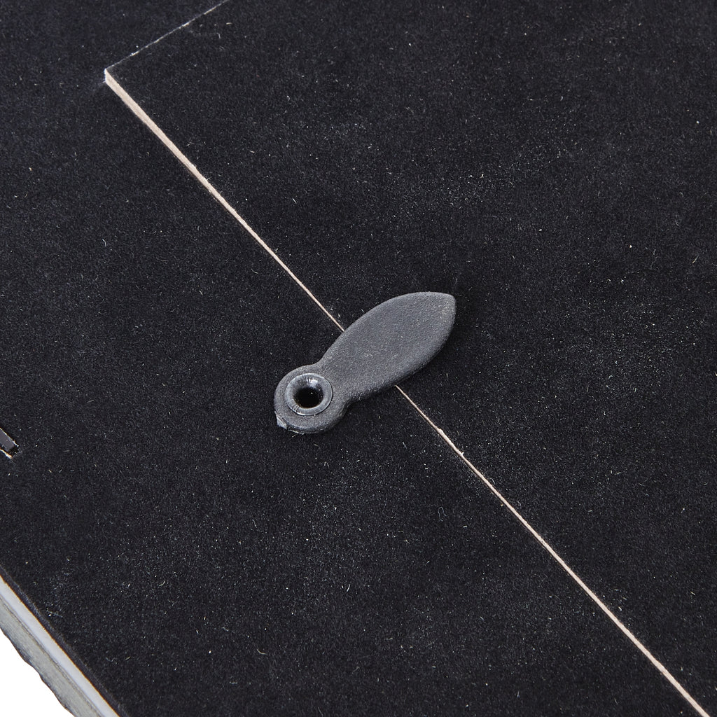 Detail of an oval turn tab crossing the edge of the dark rear panel.