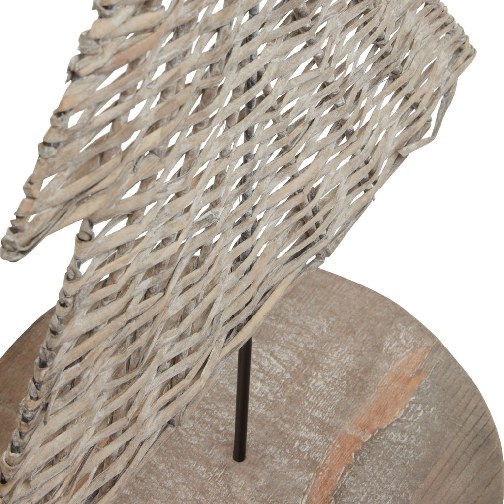 Close-up of the tree ornament's interlaced pale strips, open weave and dark support rod above the grain-patterned round base.