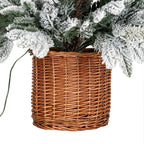 Close-up of the brown woven pot beneath snowy green branches, with a green cable visible along the left side.